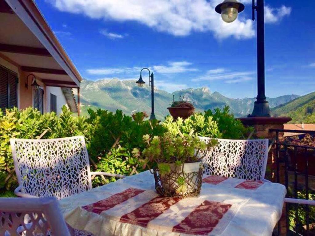 a table and chairs on a balcony with a view of mountains at Green Sunset in Tramonti