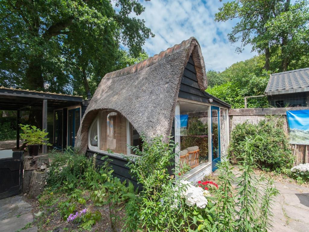 a small house with a thatched roof at Holiday Home Bergen near Forest & Beach in Bergen