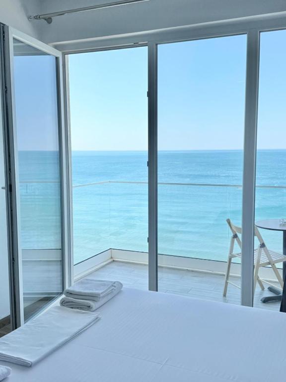 a bedroom with a bed and a view of the ocean at Megi's apartment in Shëngjin