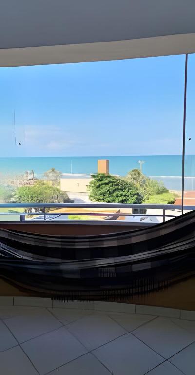 a large window in a building with a view of a beach at Flat beira-mar Natal in Natal