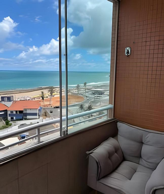 a room with a couch and a view of the ocean at Flat praia a beira-mar in Natal