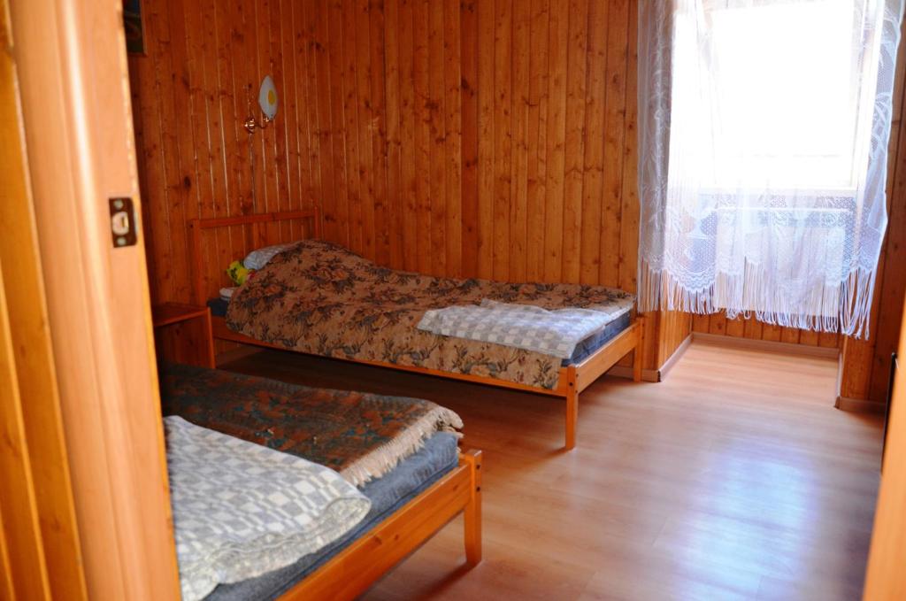 オスタシコフにあるGuest house in Ostashkovのベッド2台と窓が備わる客室です。