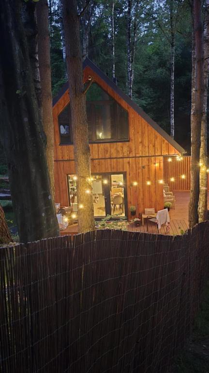 a log cabin in the woods with a fence at Dadaj Chill 2 domek nad jeziorem, wanna jakuzzi, fotel masujący in Wilimy
