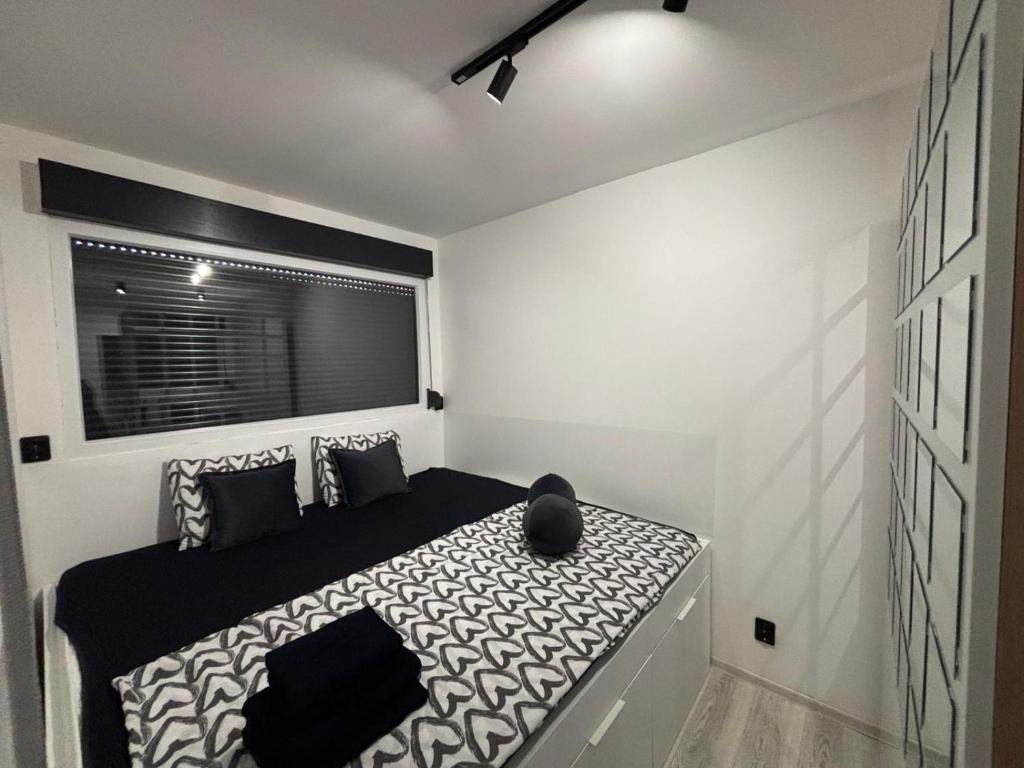 een slaapkamer met een zwart-wit bed en een raam bij Wood & Chill House in Sarajevo