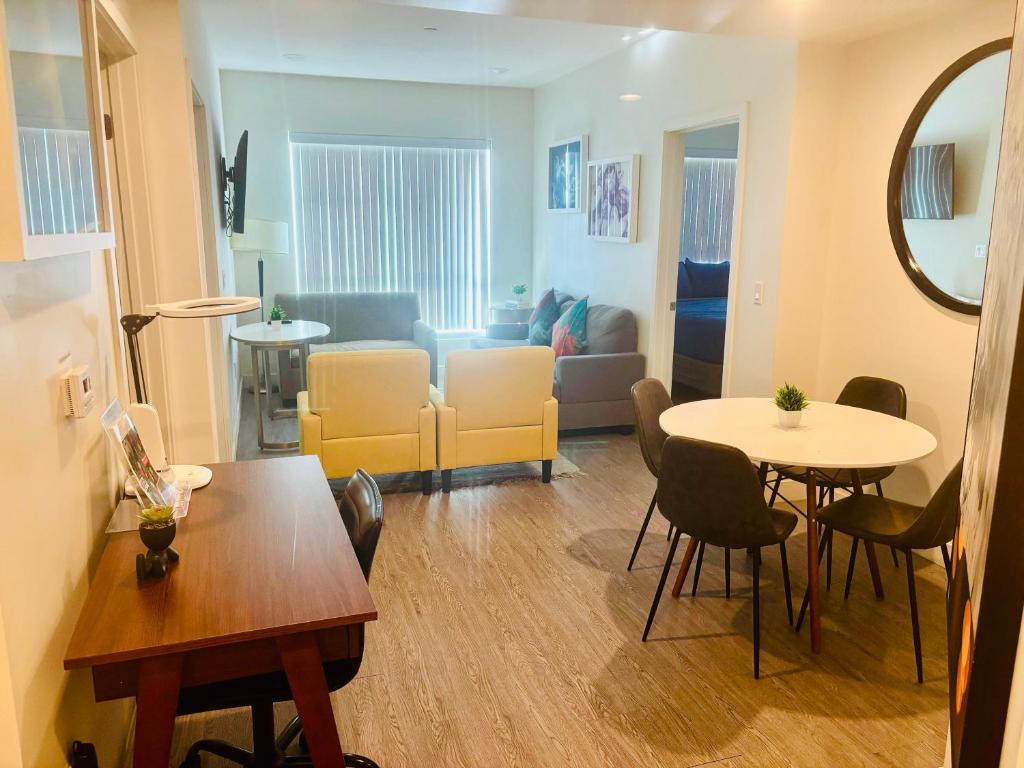 ロサンゼルスにあるUrban Chic residence in Central LAのソファとテーブルと椅子のあるリビングルーム
