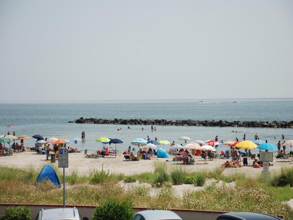 a group of people on a beach with umbrellas at Frontemare in Porto Garibaldi
