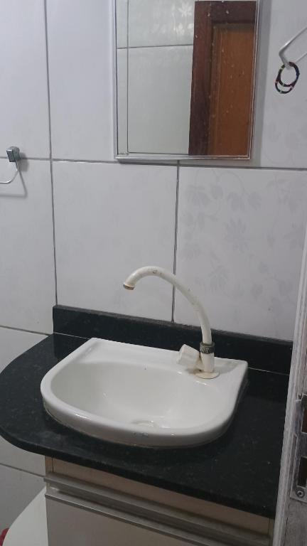 a white sink in a bathroom with a mirror at Pensão da tia Léia in Belém