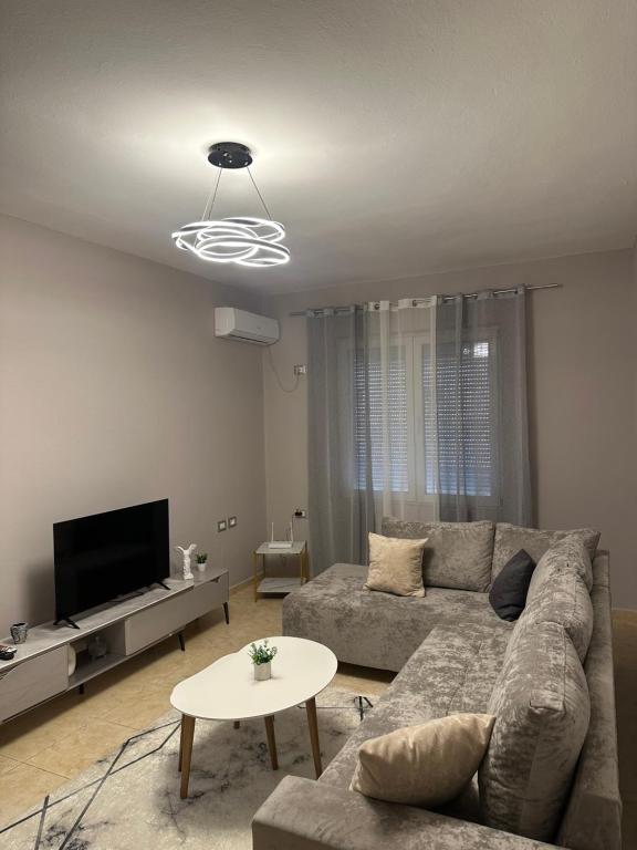 ein Wohnzimmer mit Sofa und Fernseher in der Unterkunft S&E apartments in Tirana