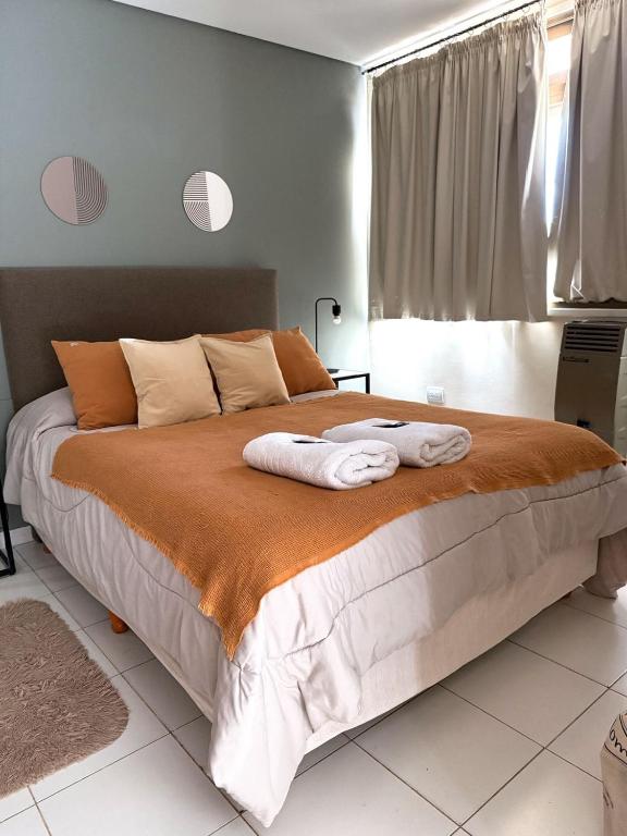 a bedroom with a large bed with two towels on it at Departamento temporal Mariano in Santa Rosa