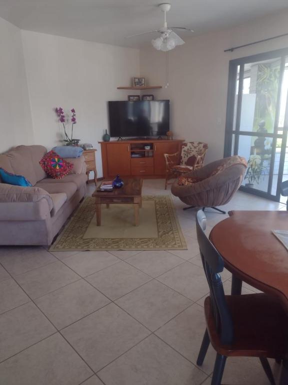a living room with a couch and a table at Apartamento à uma quadra da praia in Torres