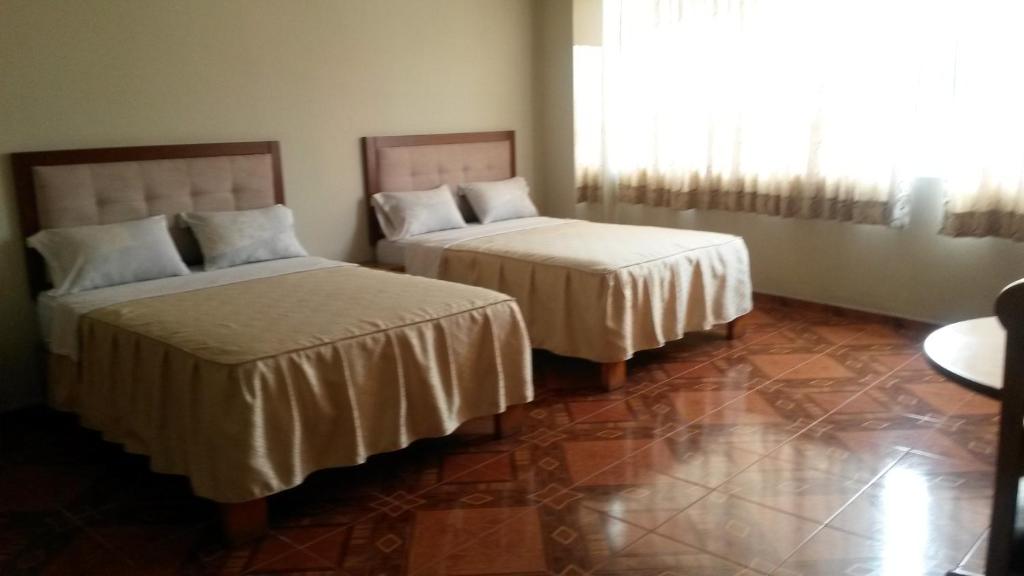 een kamer met 2 bedden en een raam bij Antares Inn in Lima