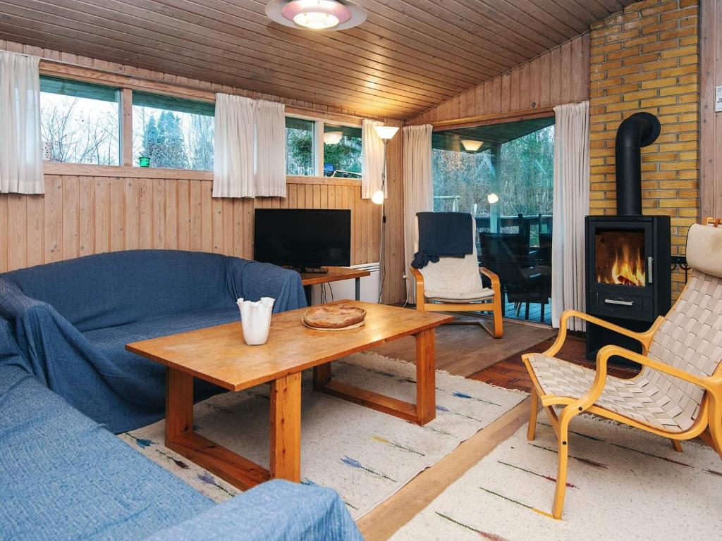 ein Wohnzimmer mit einer Couch, einem Tisch und einem Kamin in der Unterkunft 6 person holiday home in Glesborg-By Traum in Glesborg