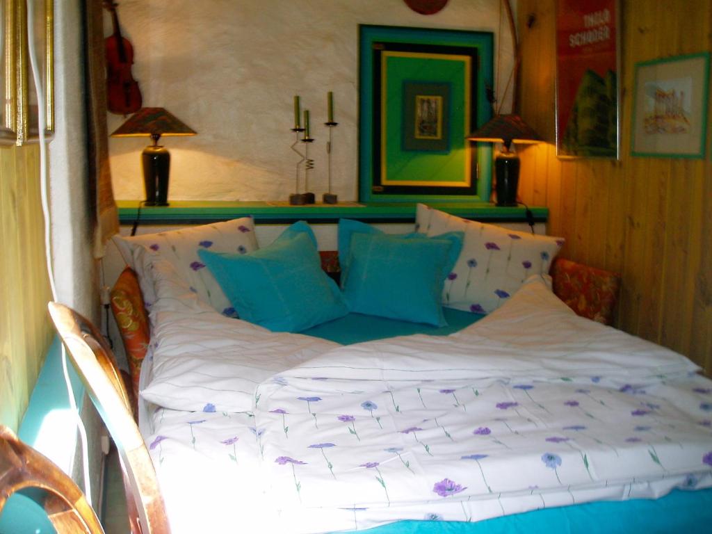 a bed with blue and white pillows in a room at Annehelenes B&B in Bergen