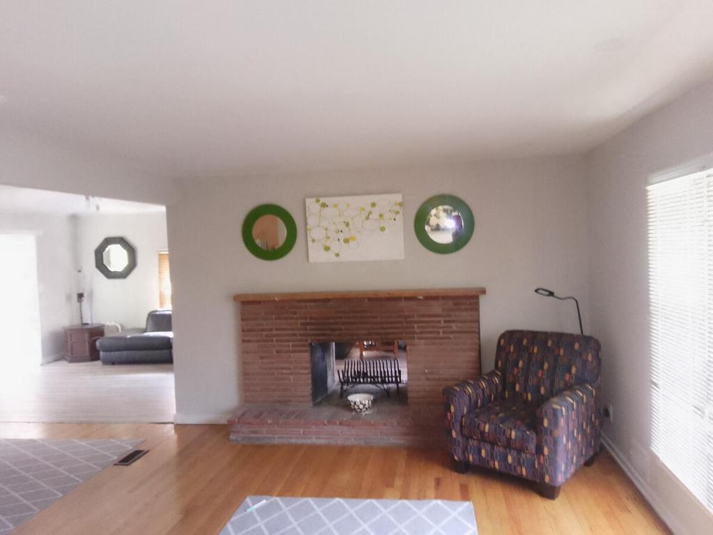 a living room with a chair and a fireplace at Royal Retreat in Kansas City