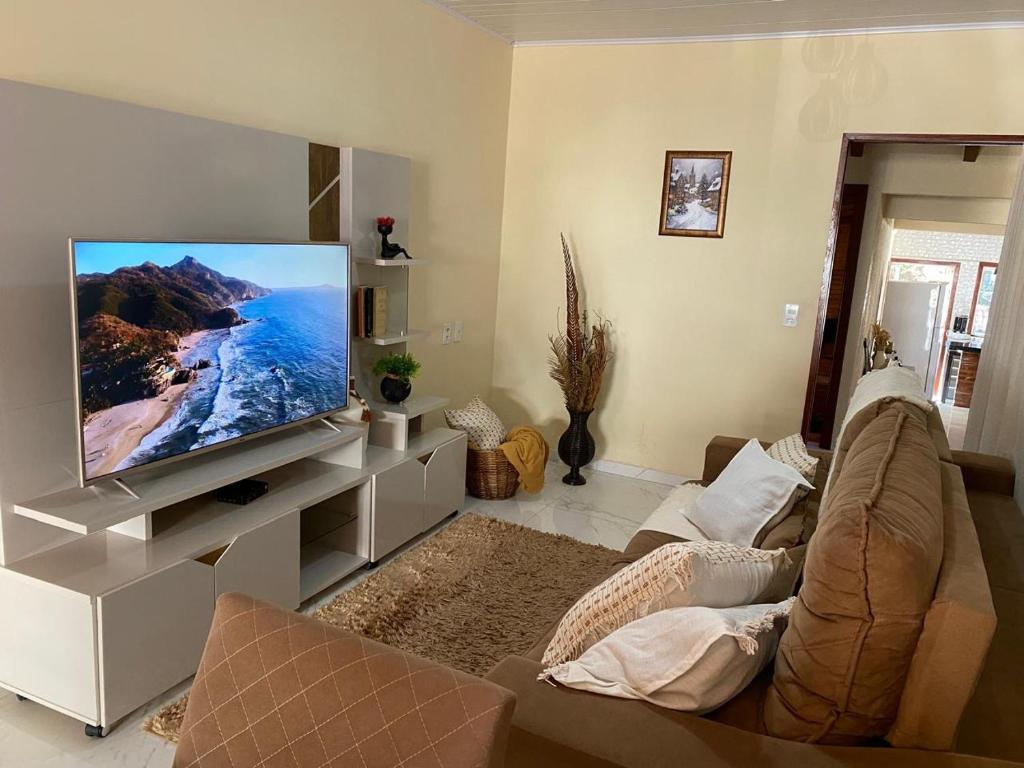sala de estar con TV y sofá en Casa de Campo Cantinho da Mata, en Domingos Martins