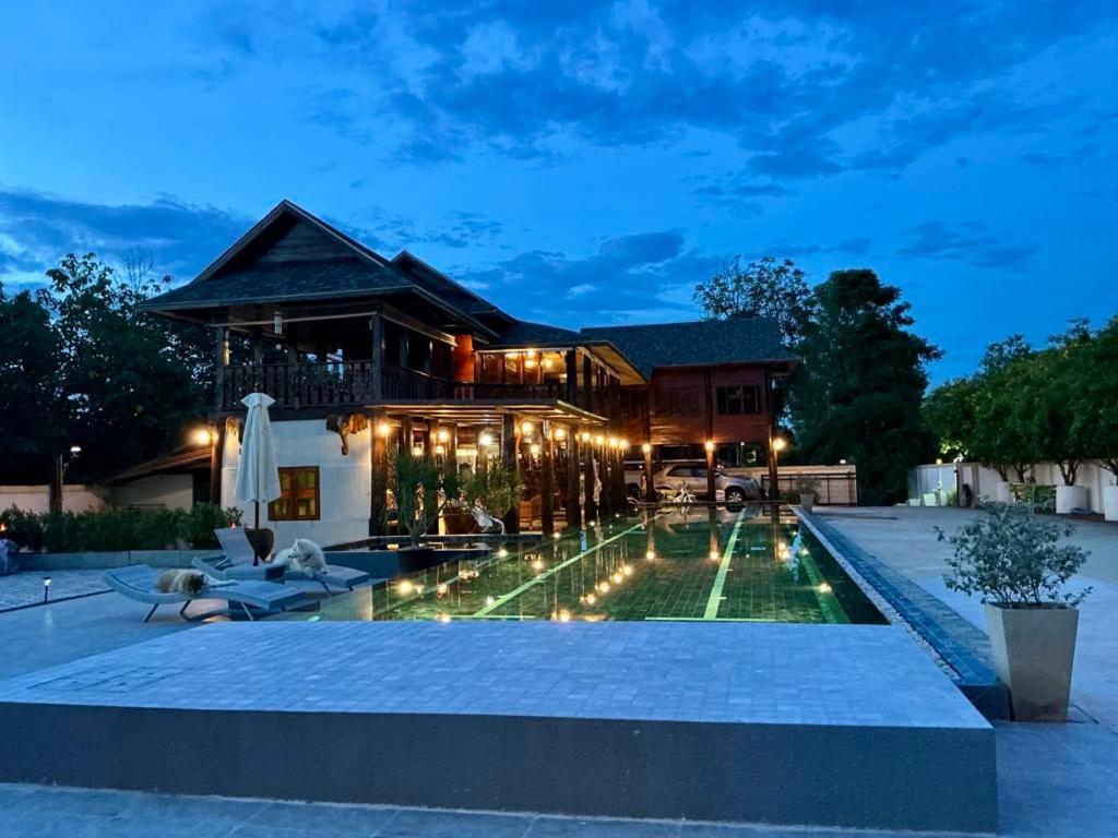 ein Haus mit Swimmingpool bei Nacht in der Unterkunft The Elephant House and Bungalows 