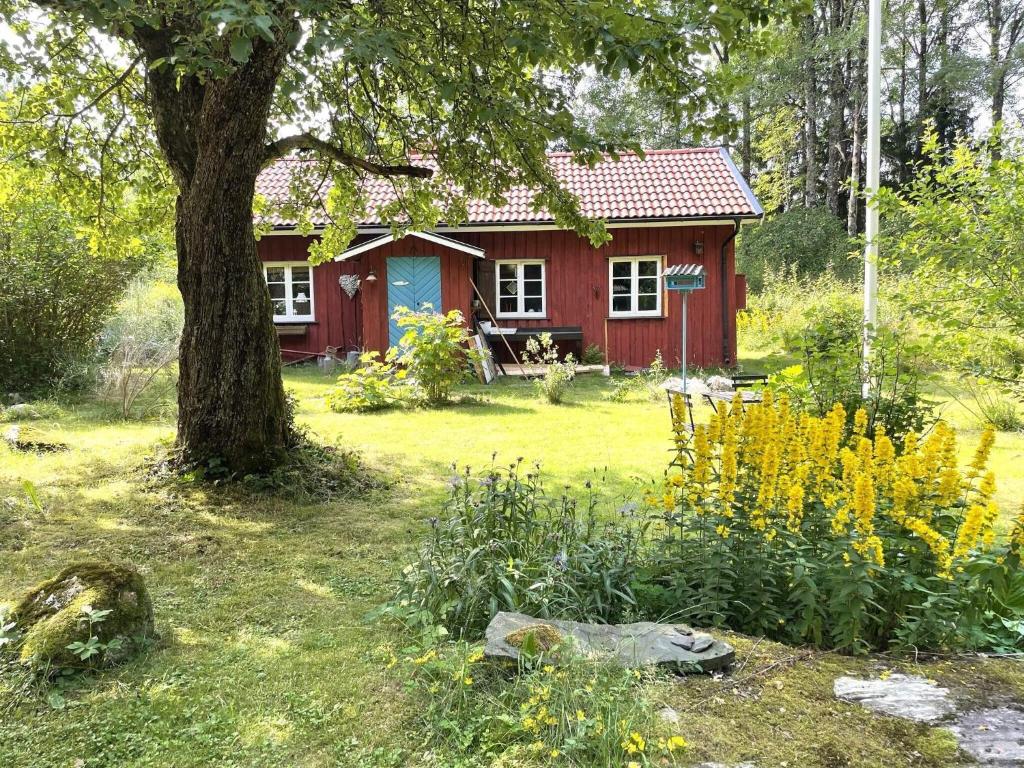 a red house with a tree in a yard at 3 person holiday home in UDDEVALLA-By Traum in Uddevalla