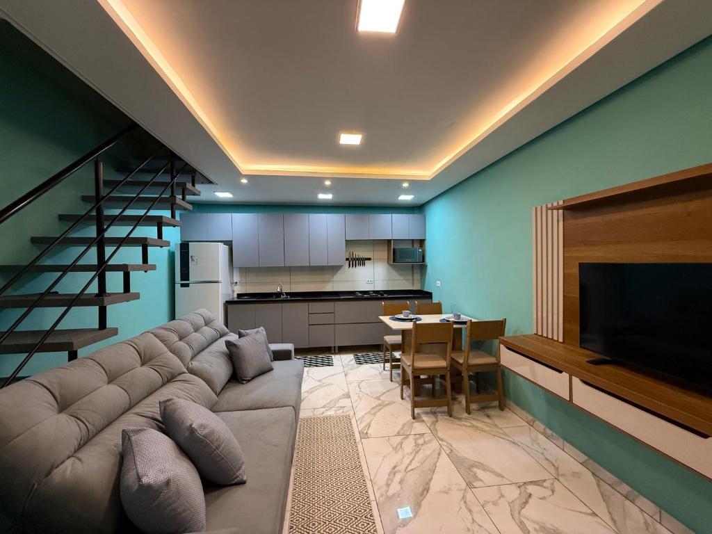 パラナグアにあるMehl Loft Ilha do Melのリビングルーム(大きなソファ付)、キッチンが備わります。
