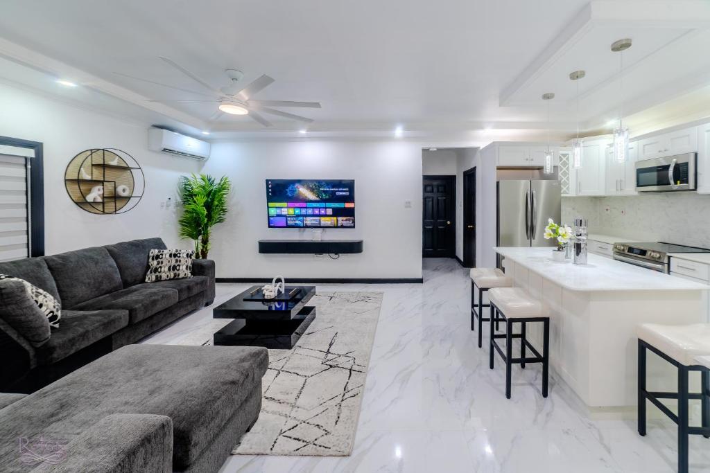 a living room with a couch and a kitchen at Platinum22 - Across From AC Marriott Hotel in Kingston