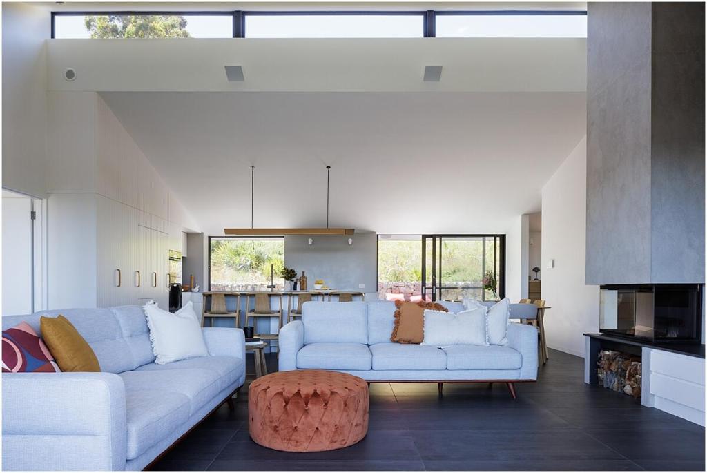 a living room with two couches and a table at Beach, Golf & Luxury! Sunrise to Sunset Views in Forster