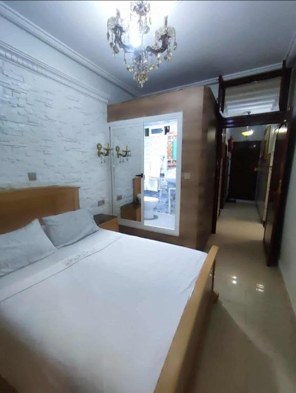 a bedroom with a large white bed and a chandelier at Dar NABIL in Chefchaouen