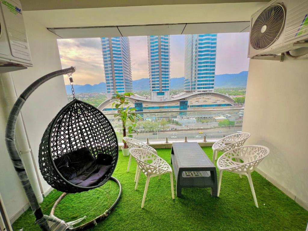 a room with a swing and a table and chairs at Elysium Tower Premium Serviced Apartments Facing Centaurus Mall Islamabad in Islamabad