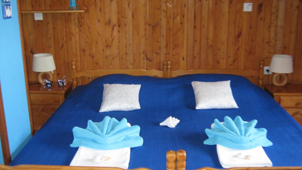 a bedroom with a blue bed with towels on it at Perun Guest House in Mlini