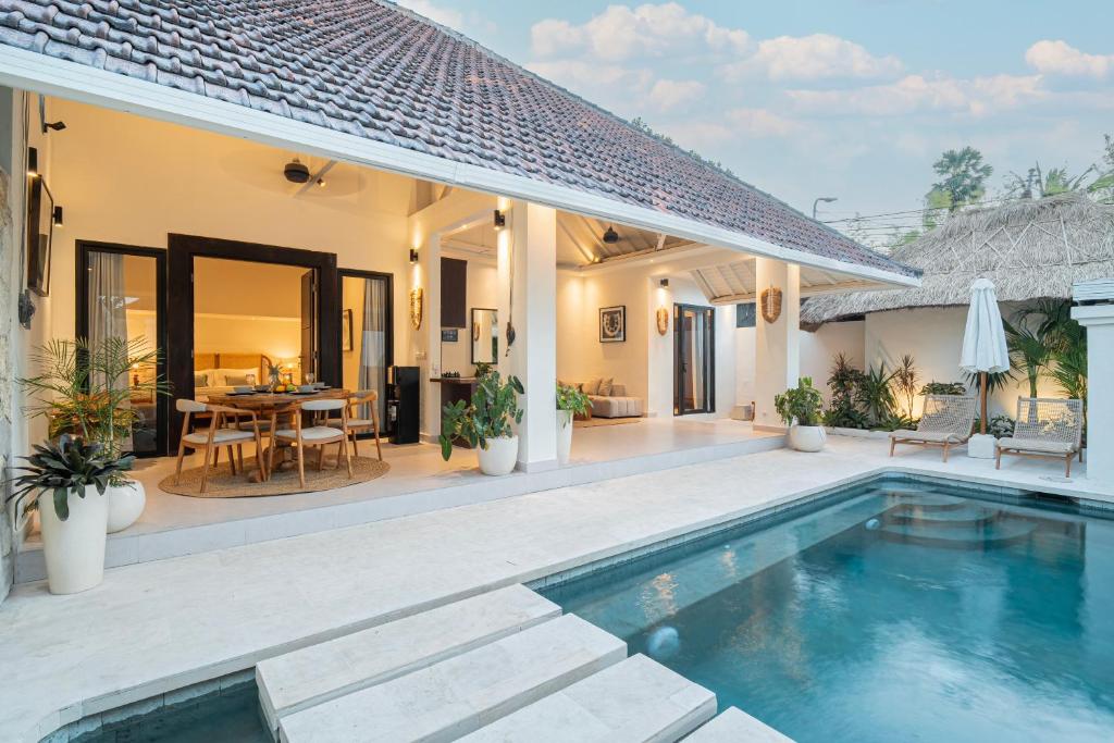 une villa avec une piscine et un coin repas dans l'établissement Coral Heaven 2 by Bali Villa Solutions, à Seminyak