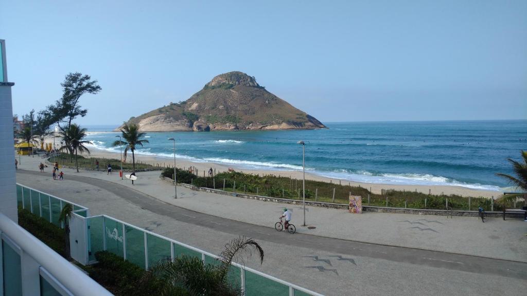 a view of a beach with a rock in the ocean at Reserva Pontal Beach in Rio de Janeiro