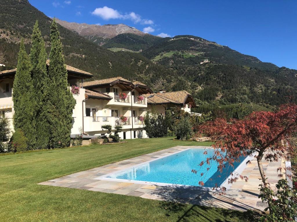 a villa with a swimming pool in front of a mountain at Apartment in Goldrain with Pool & Mountain Views in Laces