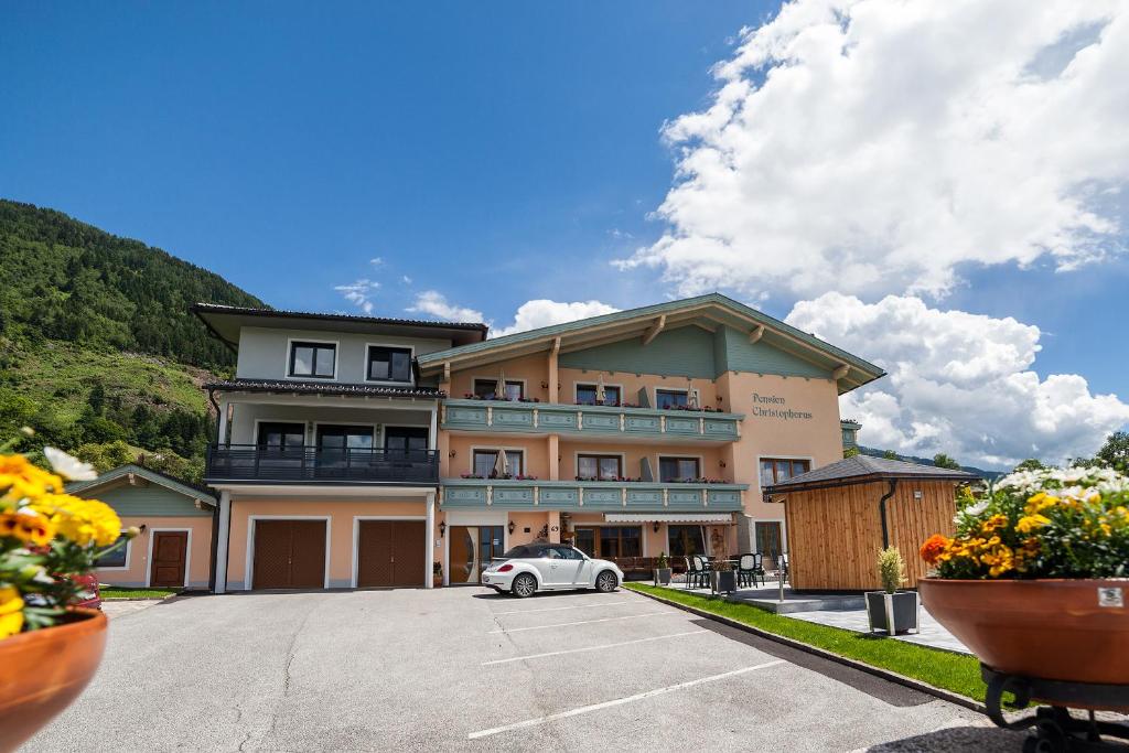 a building with a car parked in a parking lot at Pension Christophorus in Millstatt