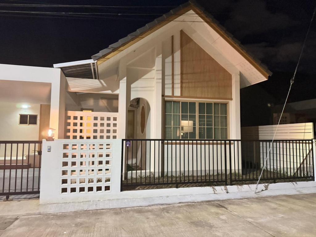 ein kleines Haus mit einem weißen Zaun in der Nacht in der Unterkunft Minimalist Haven in Ban Mai I