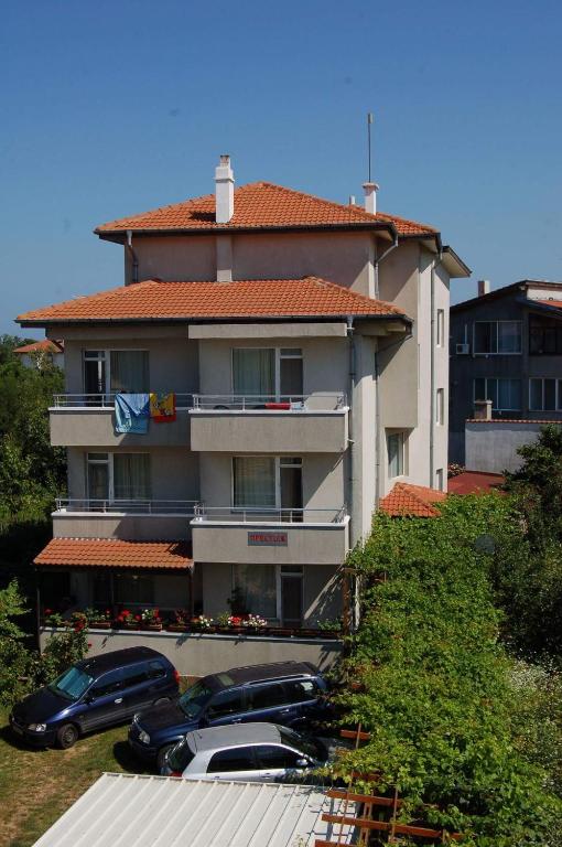 a large building with cars parked in front of it at Prestige in Sinemorets