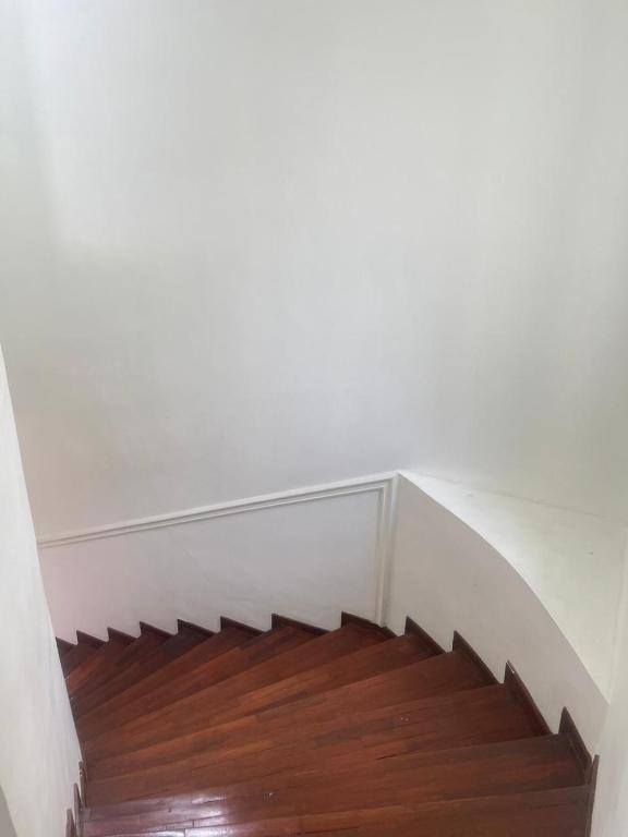 a staircase with a wooden floor and white walls at Kota bunga in Cikundul