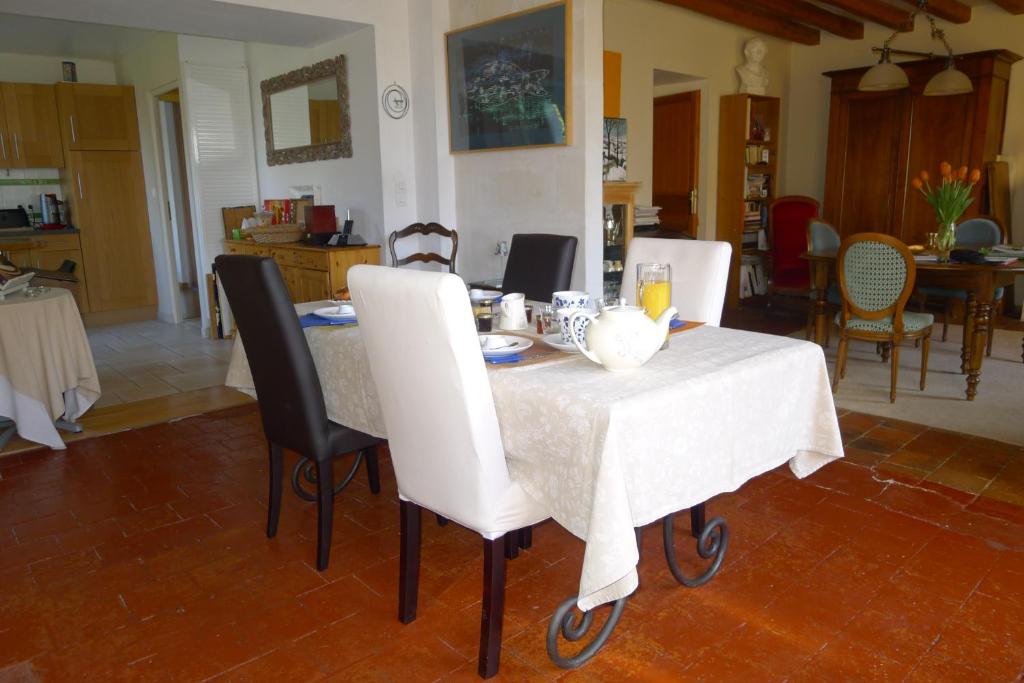 una mesa con sillas y un mantel blanco. en Chambre d'hote Le sablonnet en Ciran