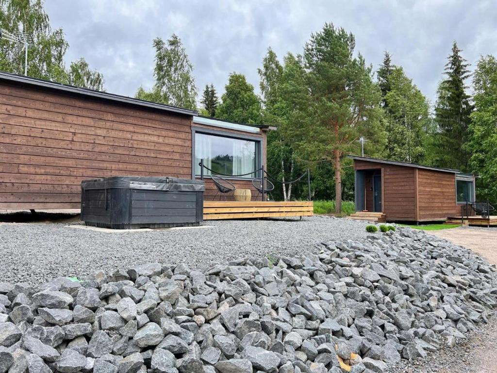a house with a pile of rocks next to a building at Himosranta Suite A - Private Suite with Hot Tub & Lake Views in Jämsä