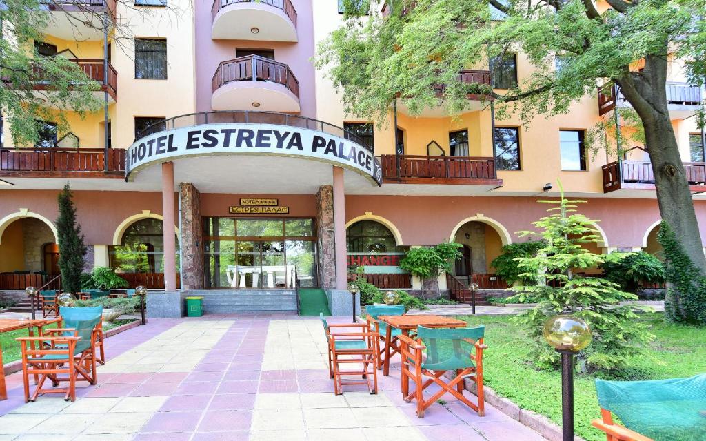 ein Hotel mit Tischen und Stühlen vor einem Gebäude in der Unterkunft Hotel Estreya Palace in Sweti Konstantin
