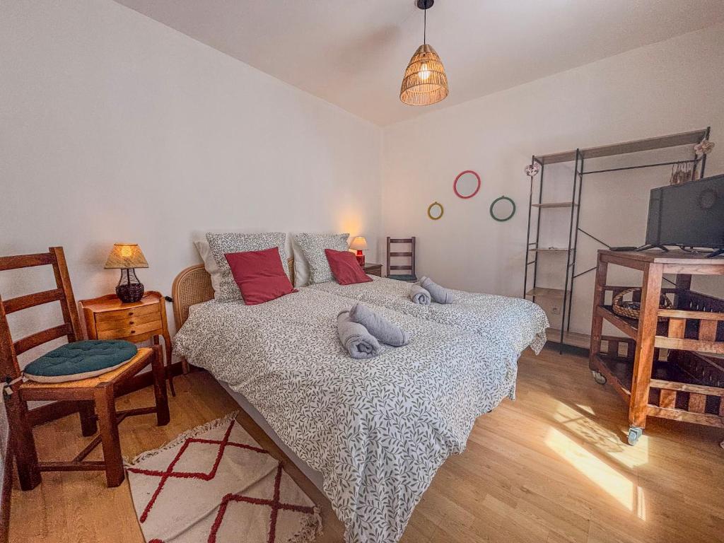 a bedroom with a bed and a tv and a chair at Le studio de saint jean in LʼAigle