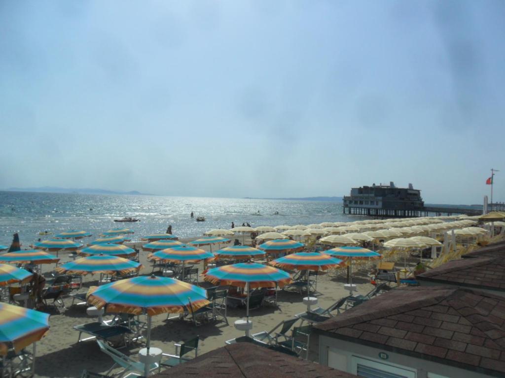 grupa parasoli i leżaków na plaży w obiekcie Parri Apartment w mieście Follonica