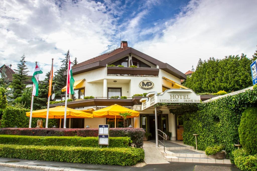 un hôtel avec drapeaux devant un bâtiment dans l'établissement Hotel Molnár, à Budapest