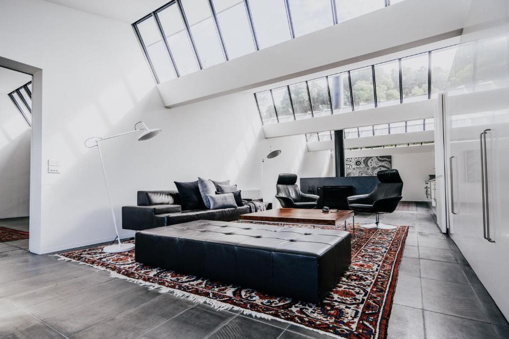 a living room with a couch and a table at Alkina Lodge Mira in Wattle Hill