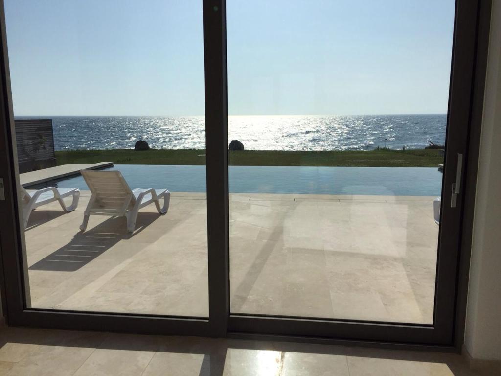 uma porta de vidro deslizante com vista para o oceano em Villa Cape Vergoti em Lozenets