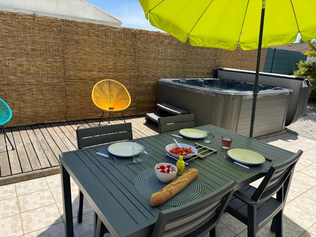 un tavolo blu con del cibo sopra e un ombrellone di Maison idéale pour un séjour aux Sables d'Olonne a La Pironnière