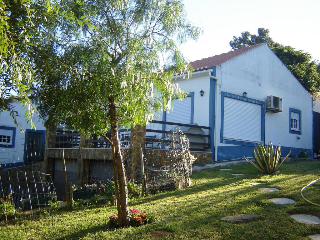 uma casa com uma árvore no quintal em Casa do Rio em Louriceira de Baixo