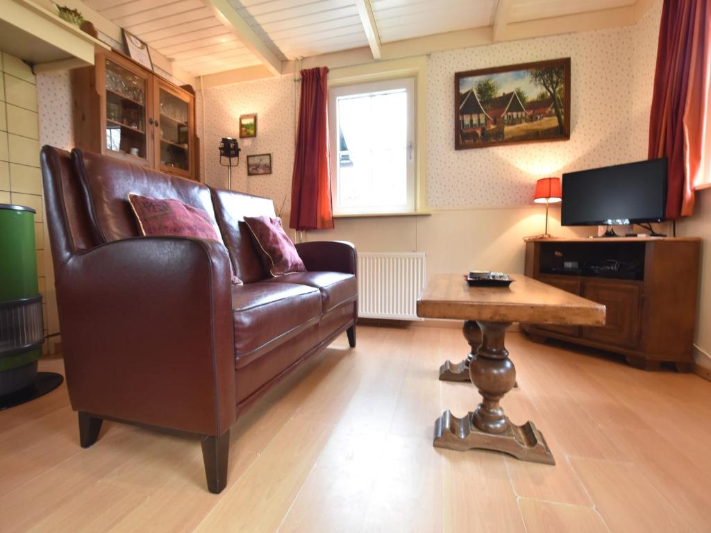 a living room with a leather couch and a table at Holiday home in with cycling area in Den Ham