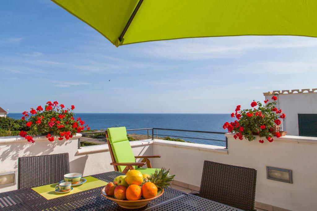 a table with a bowl of fruit on a balcony with the ocean at Salento Mare Daniela in Leuca