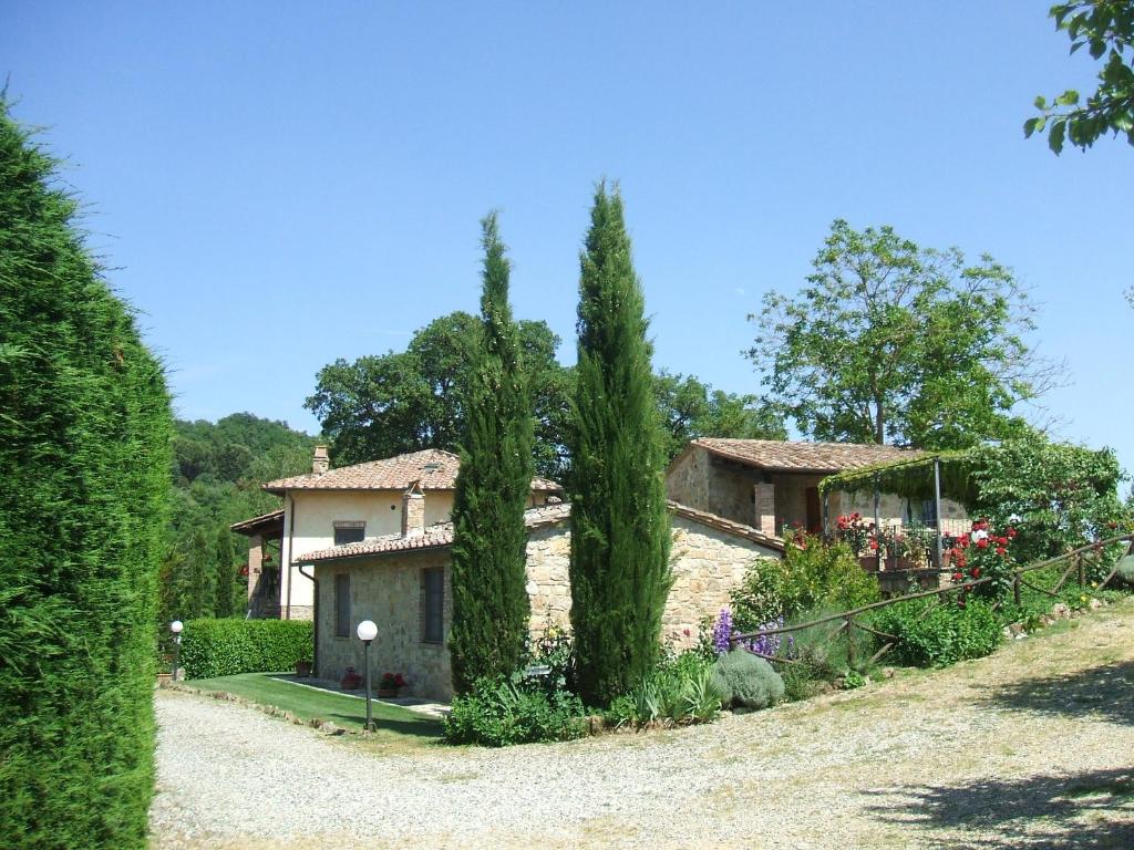 una casa con árboles frente a un patio en Borgo del Molinello, en Sant'Albino