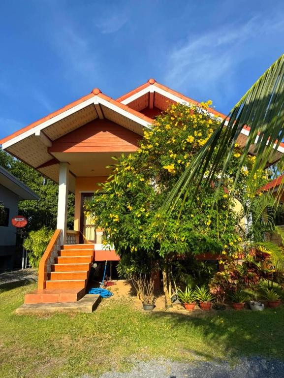 Una pequeña casa con escaleras y una palmera. en Green Heaven Bungalow 1, en Nathon Bay