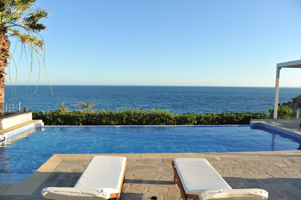 a swimming pool with a view of the ocean at Villa Sealine in Pefki