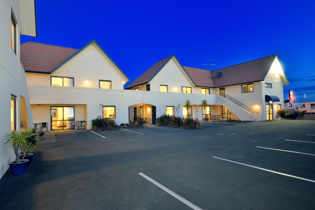 a large white building with a parking lot at night at Bella Vista Motel Gisborne in Gisborne